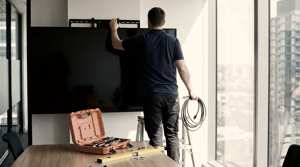 Engineer installing a meeting room display